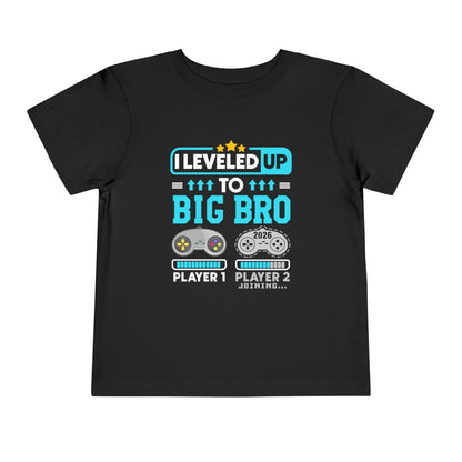 Leveled Up to Big Bro est 2026 T-shirt Black t-shirt with gaming-themed text and graphics on a white background