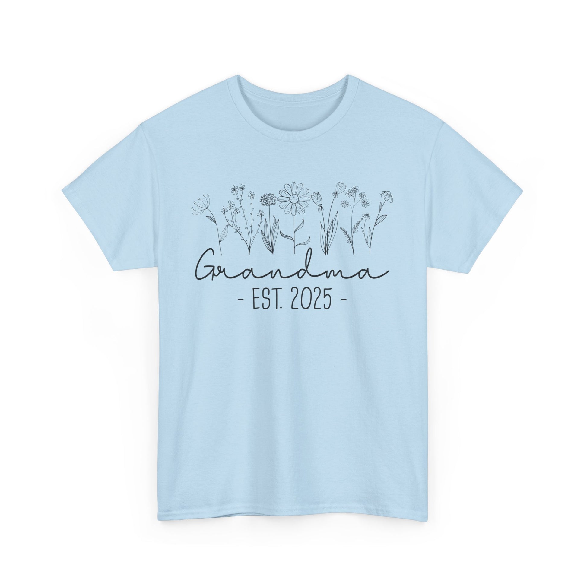 Flatlay of pink ‘Promoted to Grandma 2025’ T‑shirt styled with flowers, ideal pregnancy reveal gift flat presentation.
